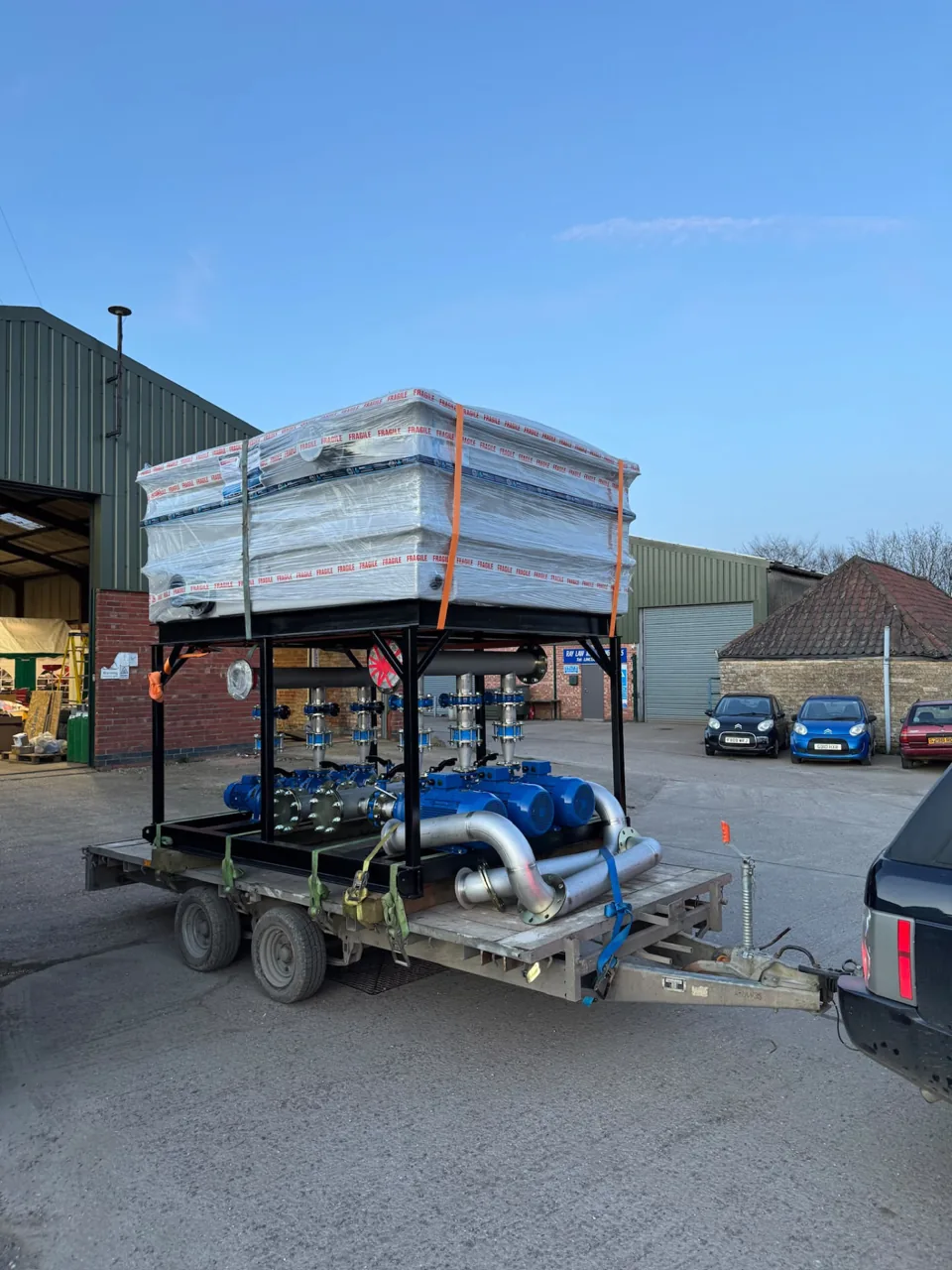 Stainless tank and pipework assembly secured on a trailer outside