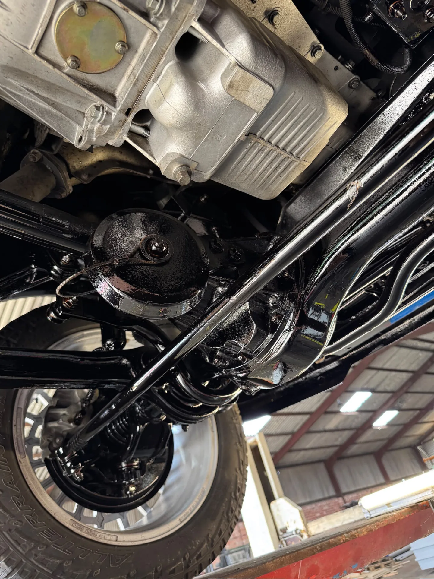 Black restored chassis, rear axle and suspension beneath a vehicle