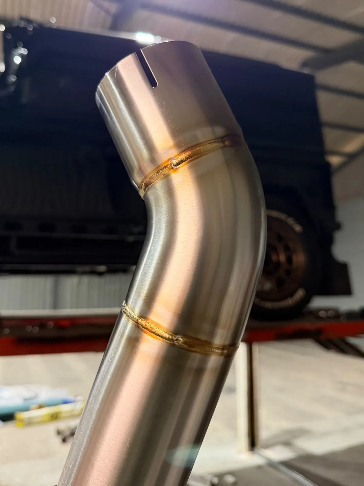 Close-up of a stainless exhaust bend and its welded joints