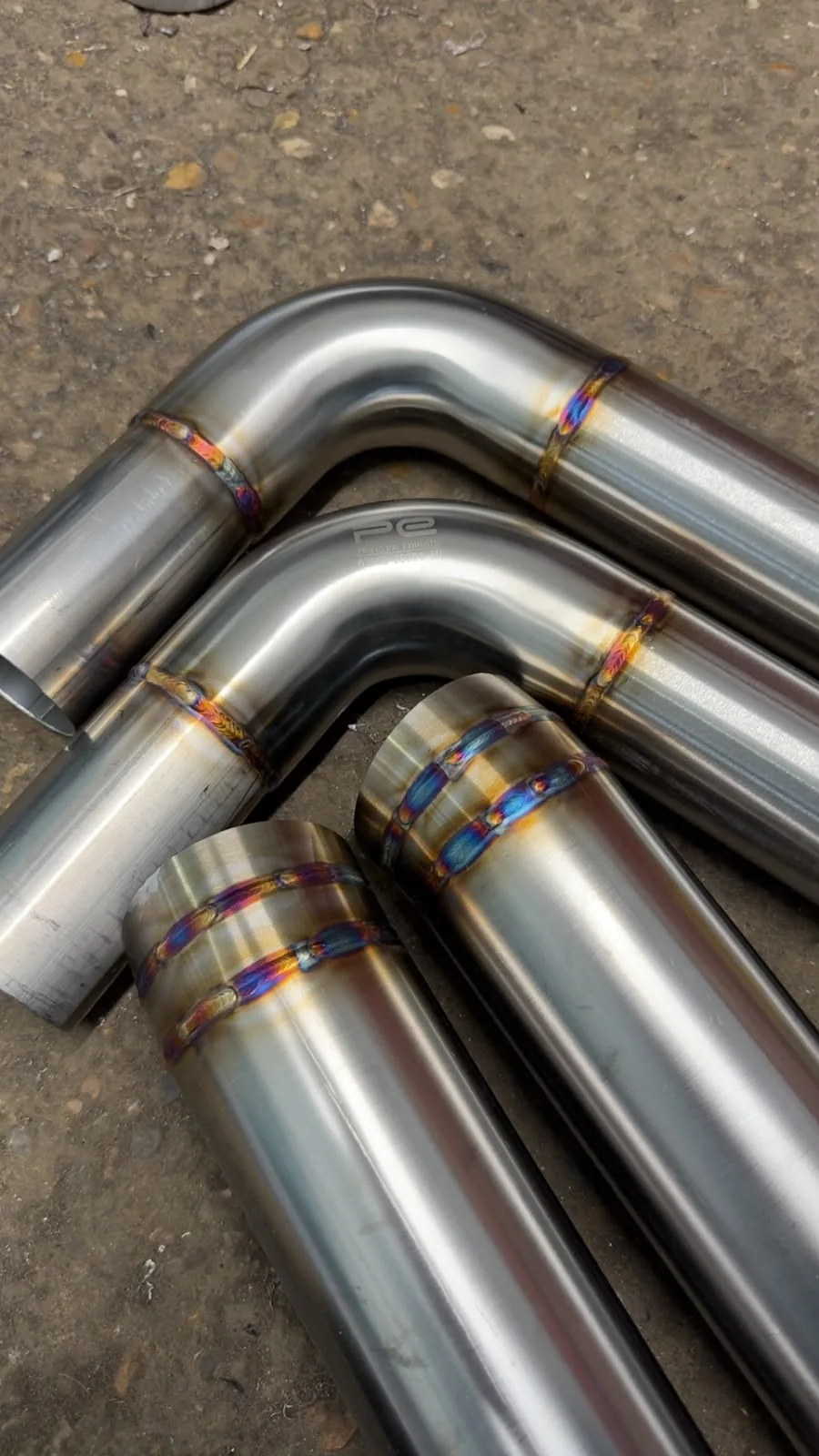 Curved stainless exhaust pipes with close-up TIG welded seams