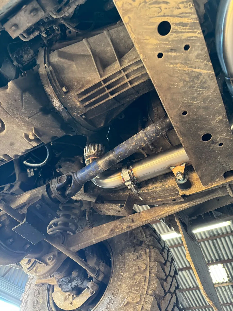 Stainless exhaust tubing routed beneath a vehicle chassis