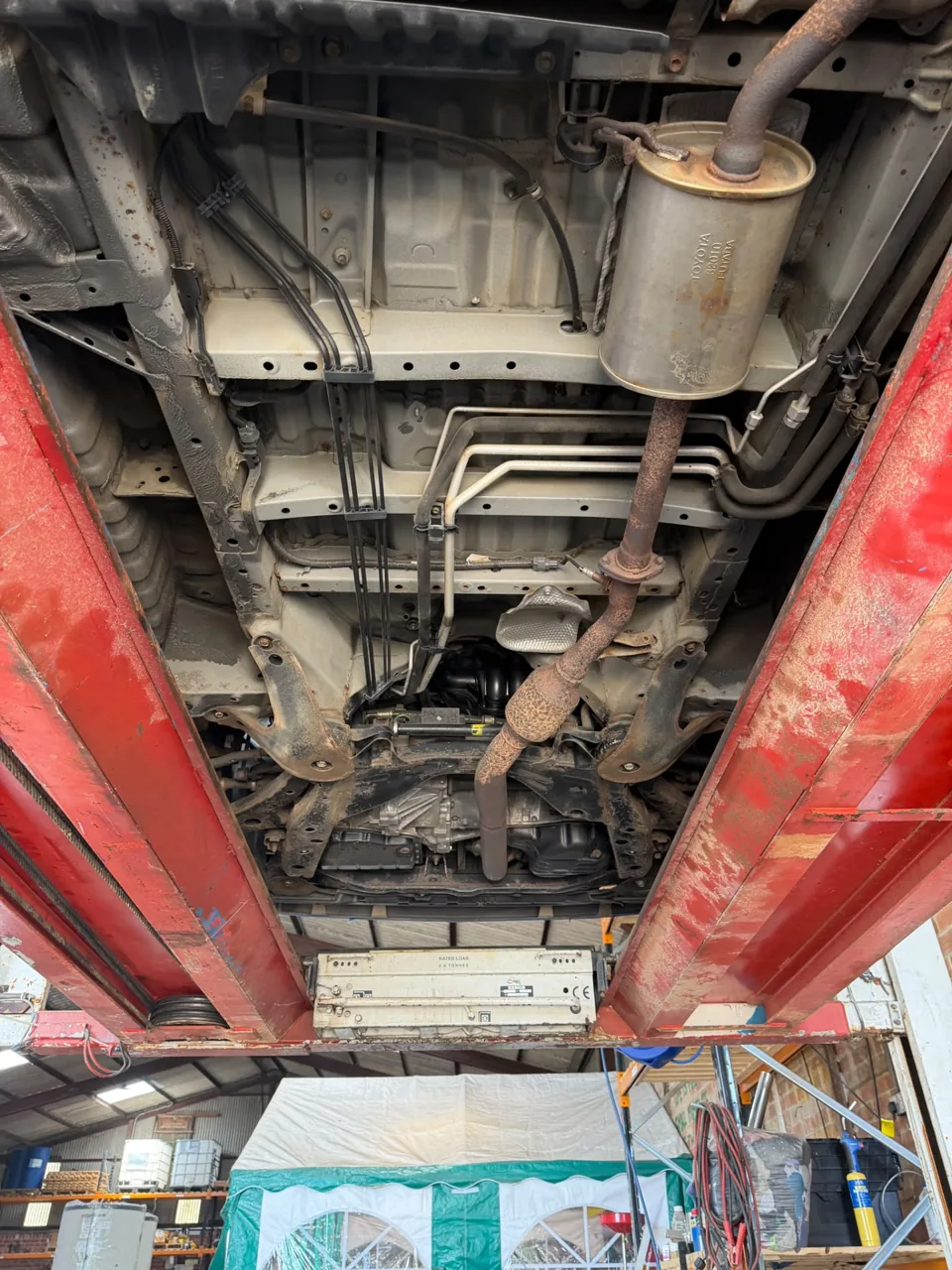 Vehicle underbody with exhaust, fuel tank and exposed chassis rails